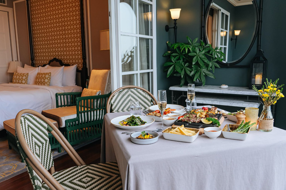 Một góc bàn ăn được setup ngay tại phòng khách sạn Mia Saigon đầy tinh tế với đầy đủ món ăn mà bạn yêu cầu